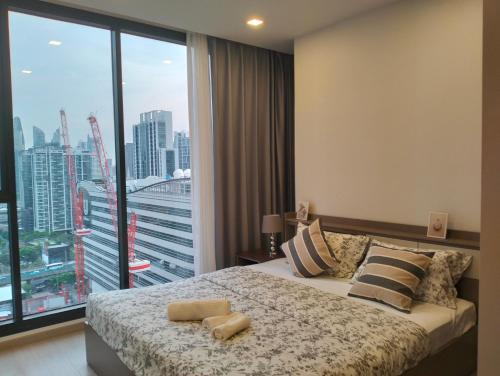 a bedroom with a bed and a large window at Free airport pick-up/Aerial rainforest/Near subway line/Train night market/Central rama 9/Super high-rise luxury apartment/Night view/RCA in Bangkok