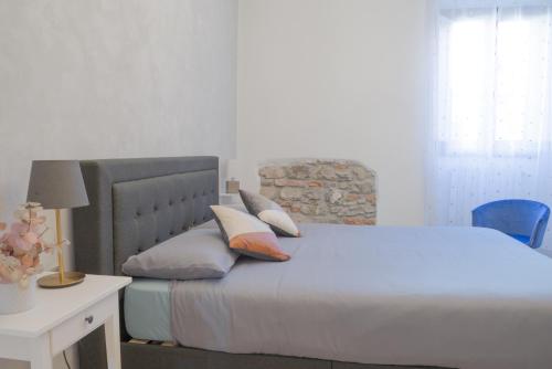 1 dormitorio con cama con almohadas y escritorio en Appartamento La Chicca en Prato