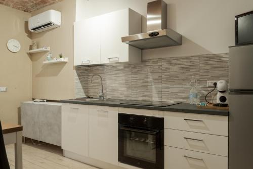 een keuken met witte kasten en een fornuis met oven bij Appartamento La Chicca in Prato