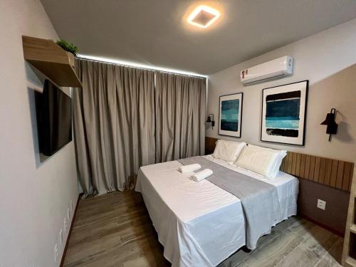 a bedroom with a white bed and a window at Luxuoso Apto na Villa de BG. in Marau
