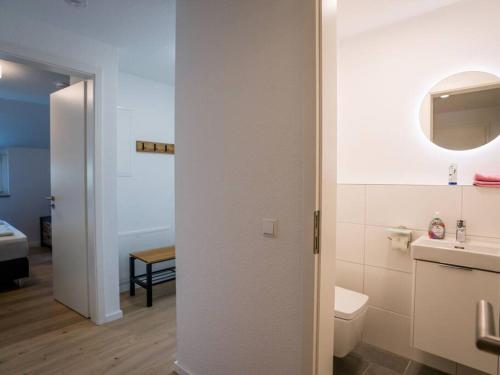 a white bathroom with a toilet and a sink at Ferienwohnung Weissach in Weissach