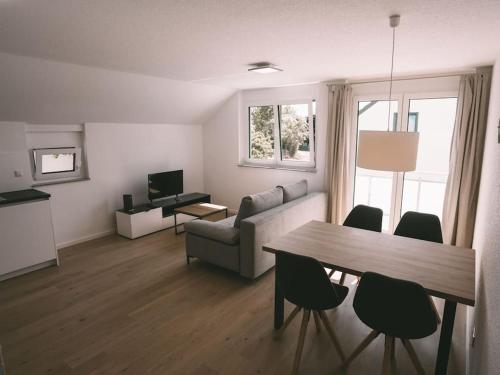a living room with a couch and a table with chairs at Ferienwohnung Weissach in Weissach