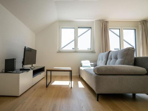 a living room with a couch and a tv at Ferienwohnung Weissach in Weissach