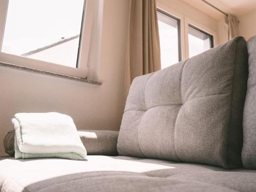a couch sitting in a room with a window at Ferienwohnung Weissach in Weissach