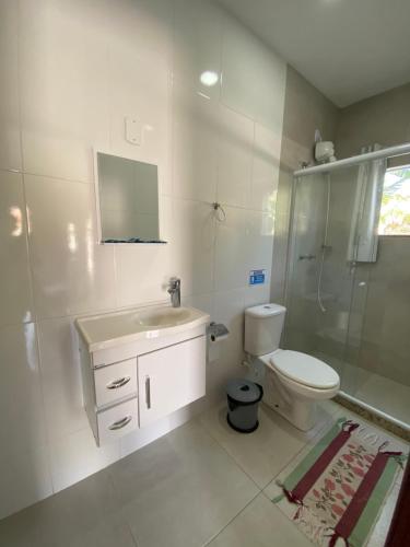 a bathroom with a toilet and a sink and a shower at Recanto Casa de Itaúna in Saquarema