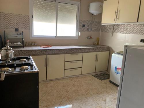 a kitchen with white cabinets and a stove top oven at Soofhouse in Fez