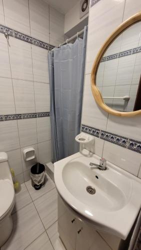 La salle de bains est pourvue d'un lavabo, d'un miroir et de toilettes. dans l'établissement Alojamiento Orejuelas #204, à Lima