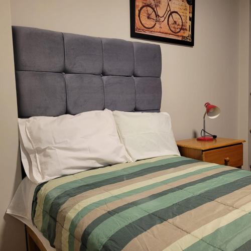 - un lit avec une tête de lit bleue dans une chambre dans l'établissement Alojamiento Orejuelas #204, à Lima