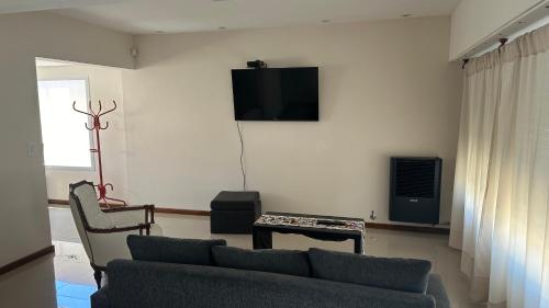 uma sala de estar com um sofá e uma televisão de ecrã plano em Casa en alquiler em Balcarce
