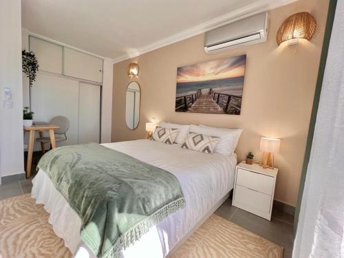 a bedroom with a bed and a painting on the wall at Oásis de verão- 2 bedrooms flat with swimming pool in Sagres