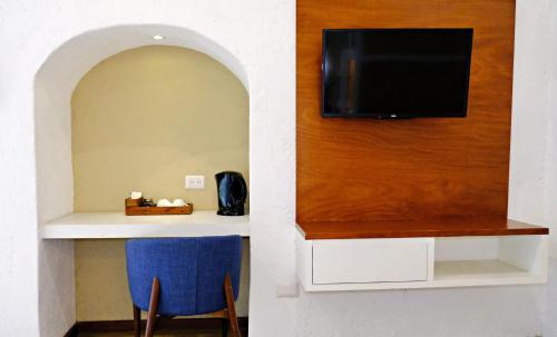 Zimmer mit einem an der Wand montierten TV sowie einem Tisch und Stühlen. in der Unterkunft Casa Pepe in Puebla