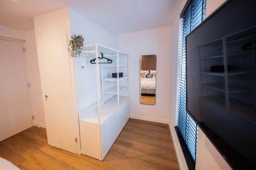 a room with a white book shelf next to a television at Luxurious 35m2 Designer Studio in Eindhoven