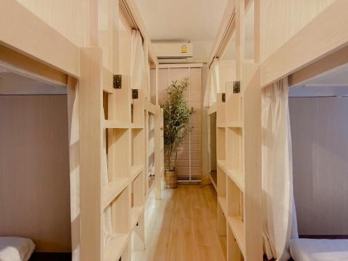 a hallway with wooden shelves in a room at Nama Hostel Chiangmai in Chiang Mai