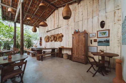 una stanza con tavoli in legno e pentole e padelle in legno di Casa da Esquina Caraíva a Caraíva
