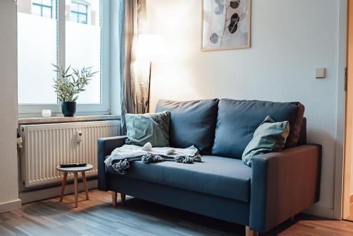 a blue couch sitting in a living room at Fewostaeps- Moderne Unterkunft, zentrumsnah in Plauen