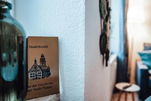 um sinal pendurado numa parede ao lado de uma garrafa em Fewostaeps- Moderne Unterkunft, zentrumsnah em Plauen