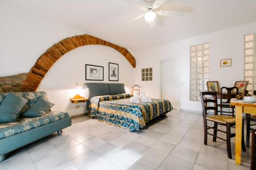 um quarto com uma cama e um sofá em Agriturismo Casa Andreina em Castiglione della Pescaia