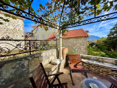 um pátio com 2 cadeiras e uma mesa em Old town house with private garden em Budva