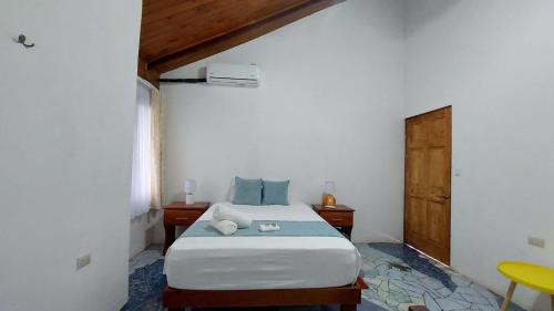 a bedroom with a bed and a wooden door at Casa THIREMA Tortuguero in Tortuguero