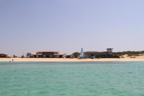 a view of a beach with a building in the background at Kaia Beach House Boa Vista Front Sea View Apartments in Sal Rei