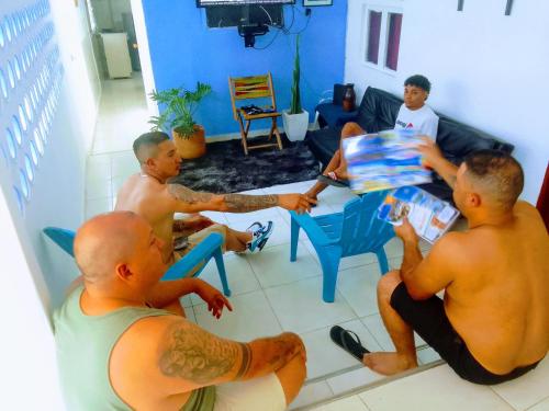 un grupo de hombres sentados alrededor de una mesa en una sala de estar en Makako Chillout Hostel, en Cartagena de Indias