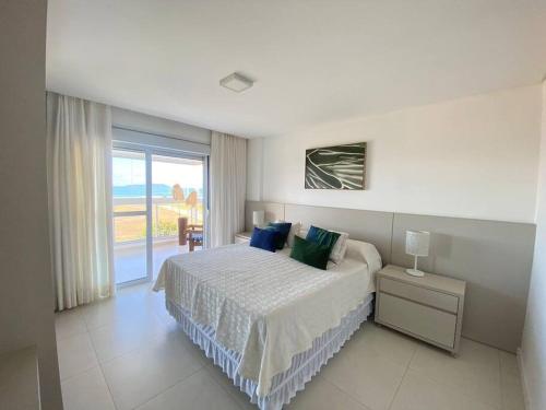 um quarto com uma cama e vista para o oceano em Apartamento com vista ampla para o mar. em Governador Celso Ramos