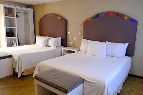 a hotel room with two beds with white sheets at Casa Pepe in Puebla