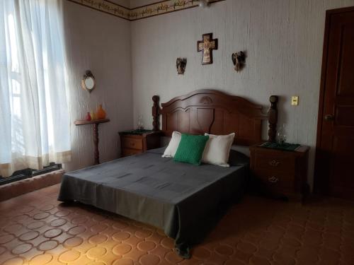 a bedroom with a bed with a cross on the wall at Peña de Bernal Rancho La Trinidad in Cerrito