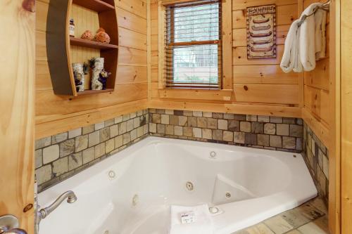 a bathroom with a tub in a log cabin at Copper Lantern in Ellijay
