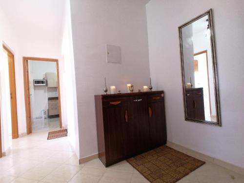 Zimmer mit einem Spiegel und einer Holzkommode in der Unterkunft Light appartement in Agadir