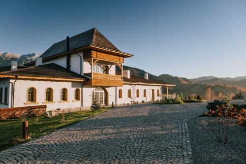 eine Kopfsteinpflasterstraße vor einem weißen Gebäude in der Unterkunft MATCA Transylvanian Sanctuary in Şimon