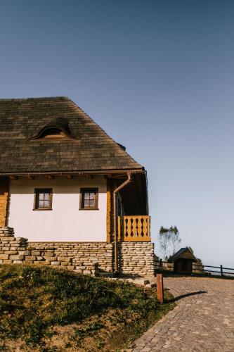 an old house with a roof on a brick road at Matca Hotel Relais & Châteaux in Şimon