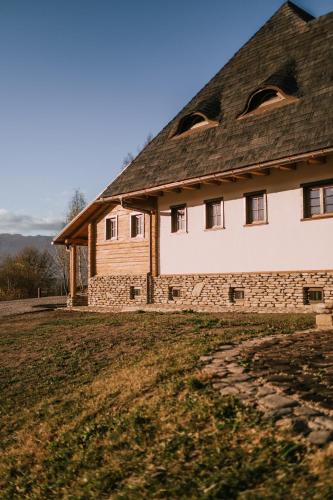 a large house with a roof on a field at Matca Hotel Relais & Châteaux in Şimon