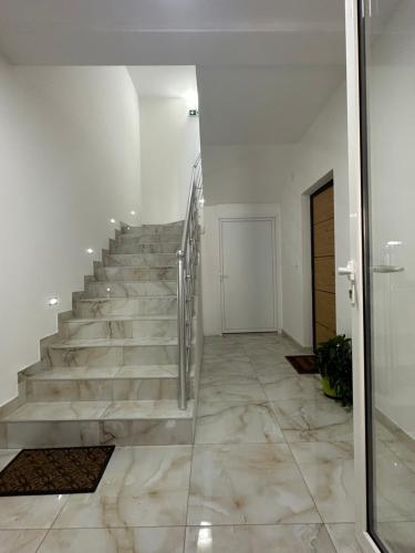 Una escalera en una habitación blanca con suelo de mármol en Kashmir, en Golubac