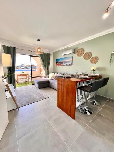 a kitchen and living room with a table and chairs at Oásis de verão- 2 bedrooms flat with swimming pool in Sagres