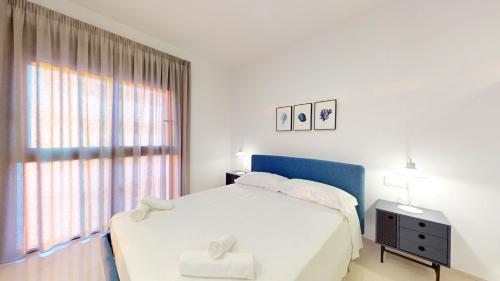a white bedroom with a bed and a window at Arenales Paradise with Pool AC Balcony and Terrace in Arenales del Sol