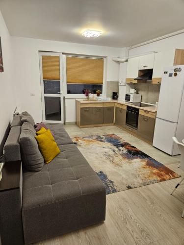 a living room with a couch and a kitchen at Apartament Bianca, în complex rezidențial Grandis in Braşov