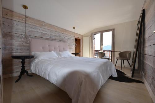 - une chambre avec un grand lit et un mur en bois dans l'établissement Appartement cosy avec vue à Montana, 