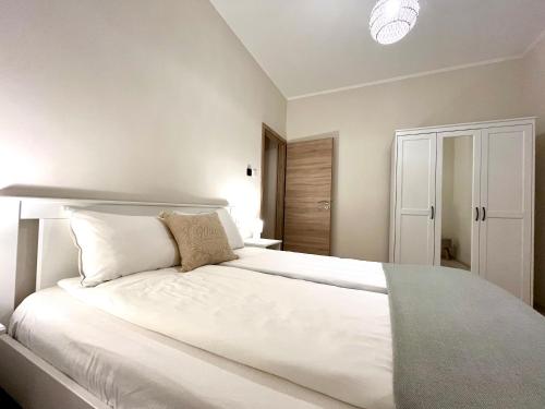 a bedroom with a large bed with white sheets and pillows at Vörösmarty apartmanház in Makó