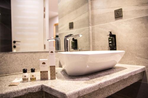 a white sink sitting on a counter in a bathroom at Metropole Hotel in Murree