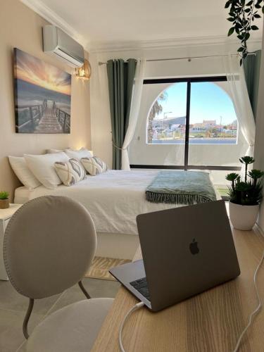 a laptop computer sitting on a desk in a bedroom at Oásis de verão- 2 bedrooms flat with swimming pool in Sagres