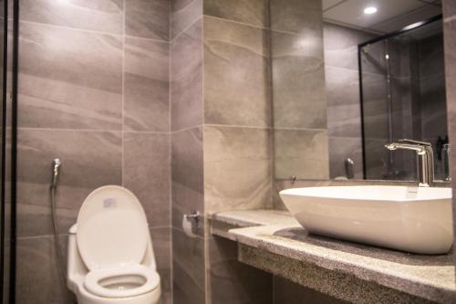 a bathroom with a toilet and a sink at Metropole Hotel in Murree