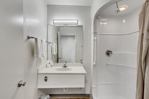 a white bathroom with a sink and a mirror at Motel 6 Ogden, UT- Downtown in Ogden