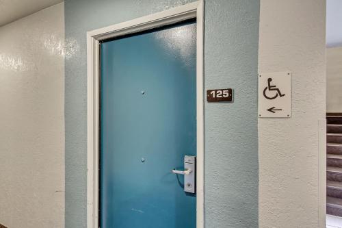 a blue door in a bathroom with a sign on it at Motel 6 Ogden, UT- Downtown in Ogden