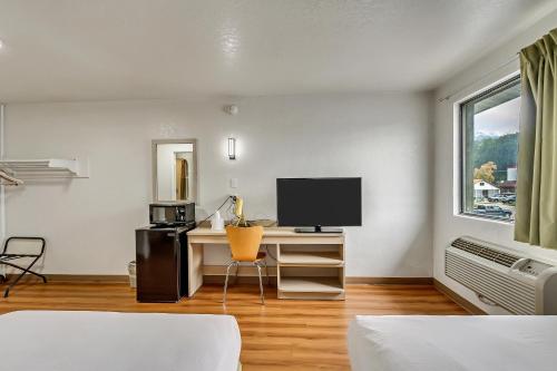 a room with a desk with a computer and a television at Motel 6 Ogden, UT- Downtown in Ogden