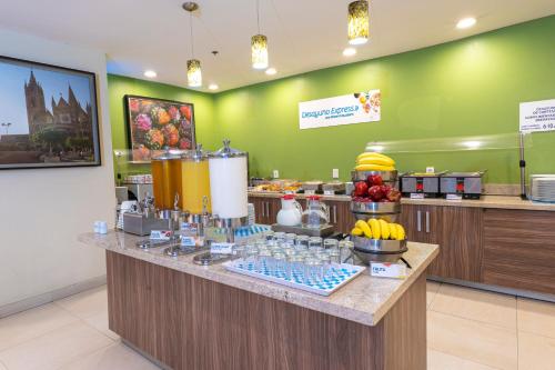 a restaurant with a counter with fruit on it at Holiday Inn Express Guadalajara Aeropuerto by IHG in Guadalajara