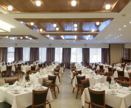 a dining room with white tables and chairs at Ramada Jerusalem Hotel in Jerusalem