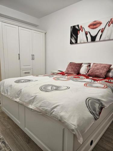 a white bedroom with a bed with faces on it at Apartament Bianca, în complex rezidențial Grandis in Braşov
