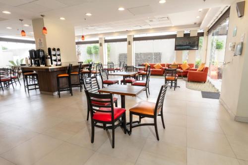 瓜達拉哈拉的住宿－快捷假日酒店瓜達拉哈拉機場酒店，餐厅设有桌椅和沙发。
