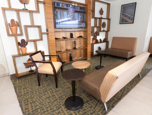 a living room with furniture and a flat screen tv at Holiday Inn Express Guadalajara Aeropuerto by IHG in Guadalajara